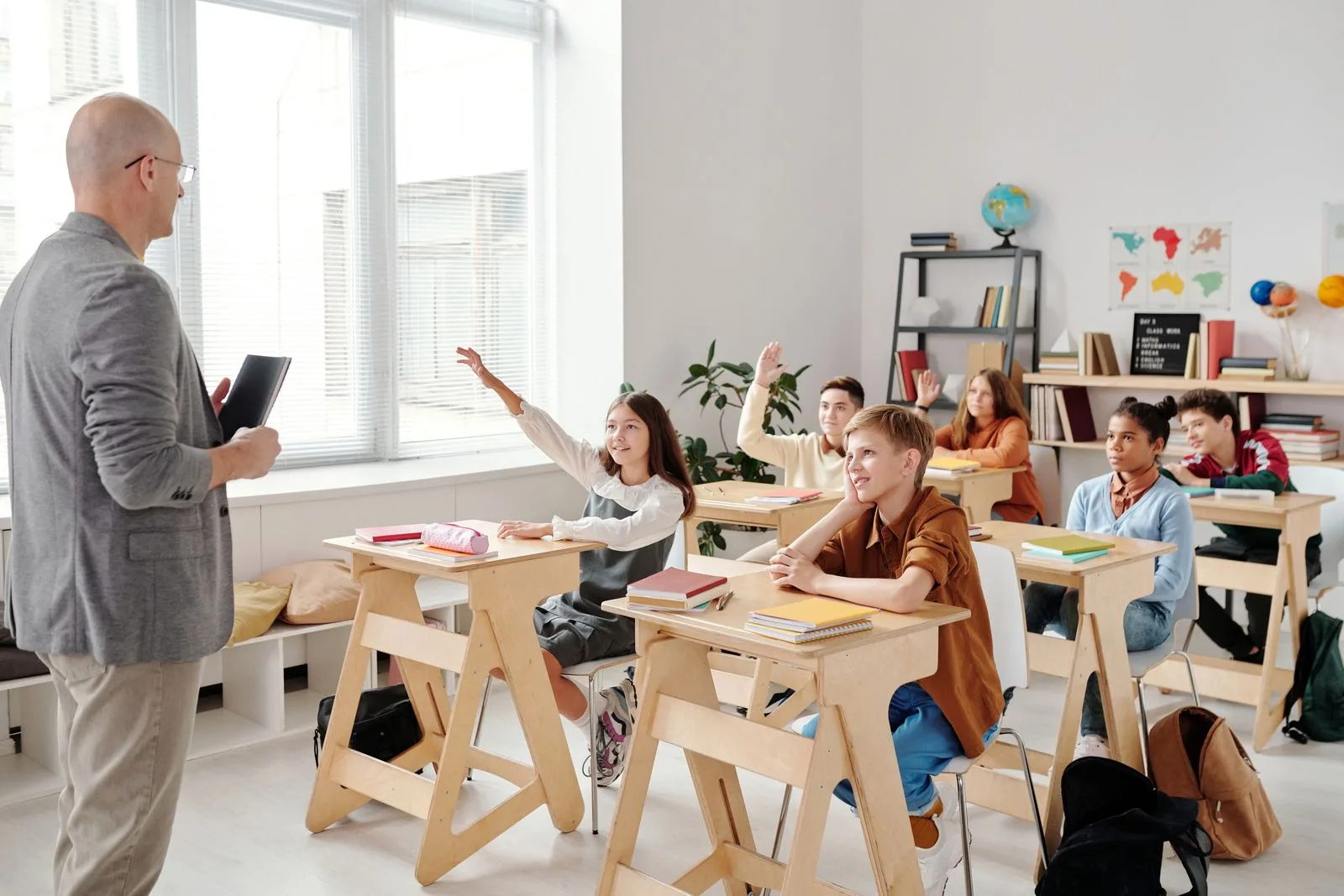 Learners raising their hands in a classroom